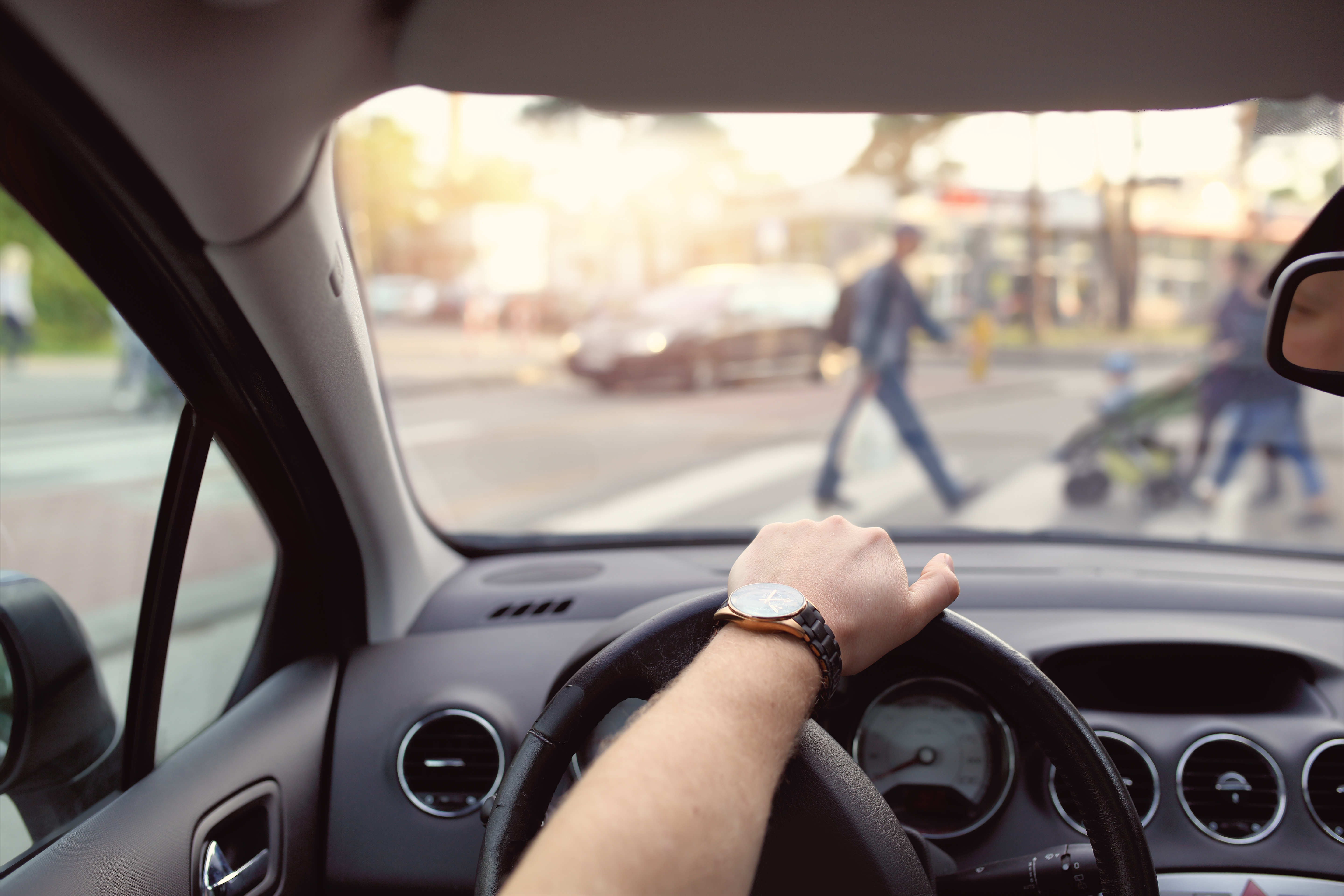 Image of hand on wheel as a person drives