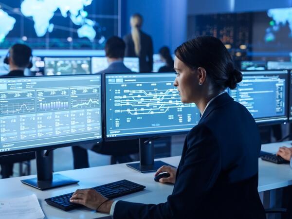 a lady working on multiple monitors